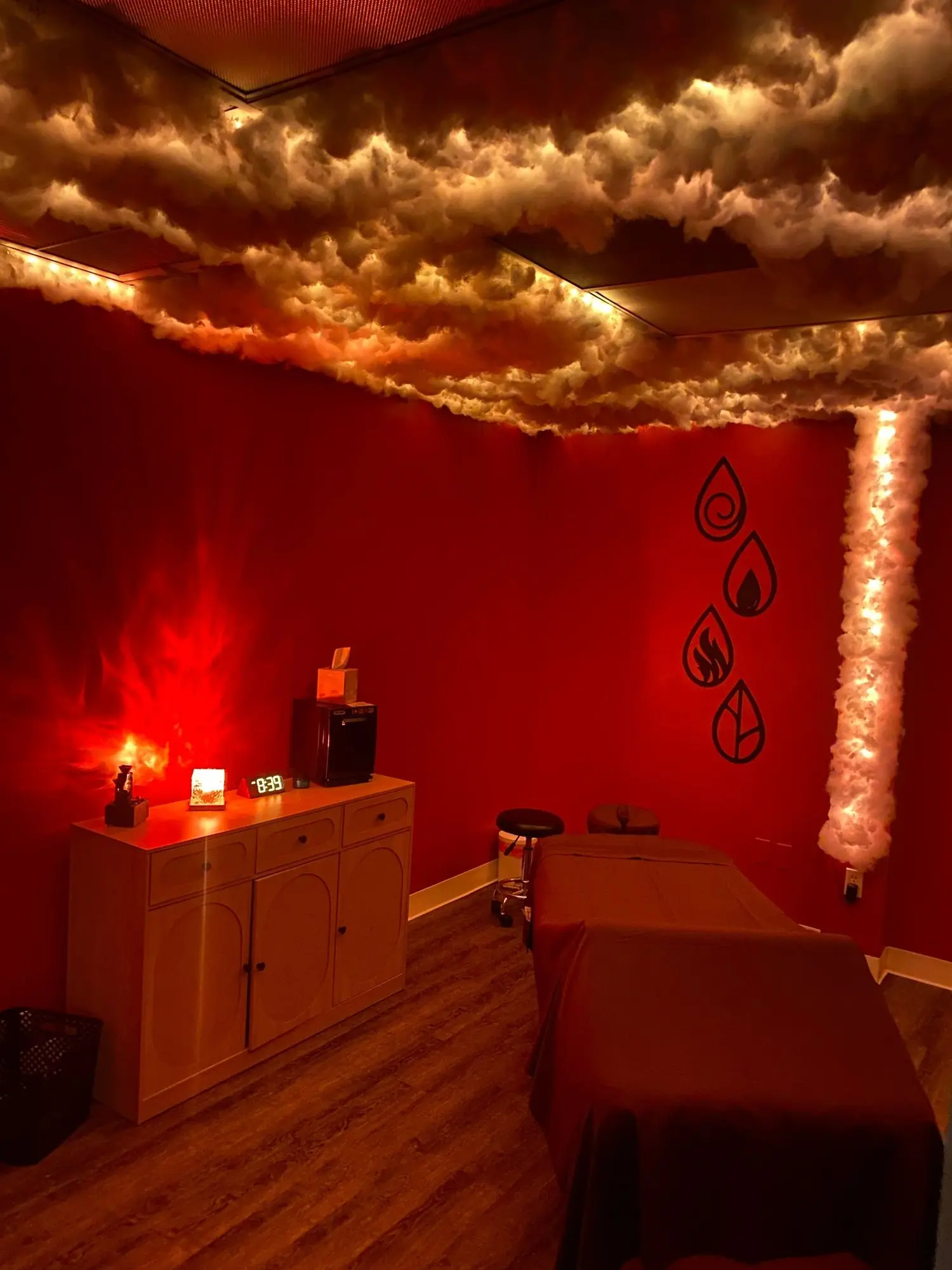 The Elemental Oasis massage room in deep red, with a cloud-covered ceiling