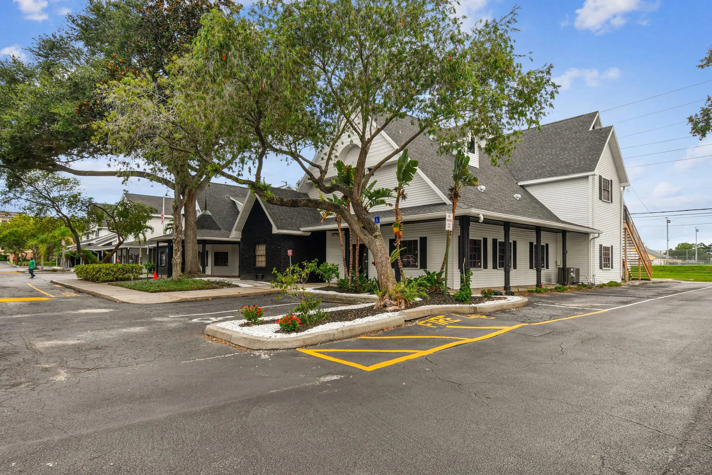 MJ Village’s renovated gabled building and front parking lot on a sunny day
