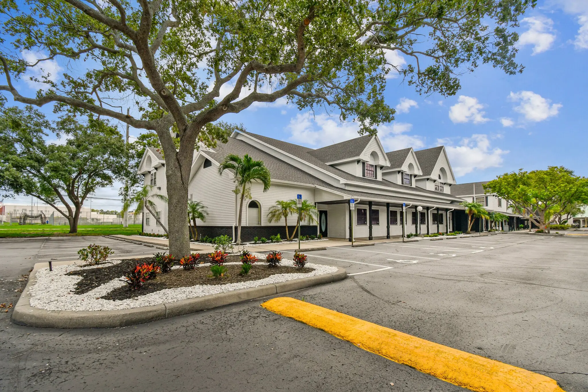 The gabled front of MJ Village under a live oak