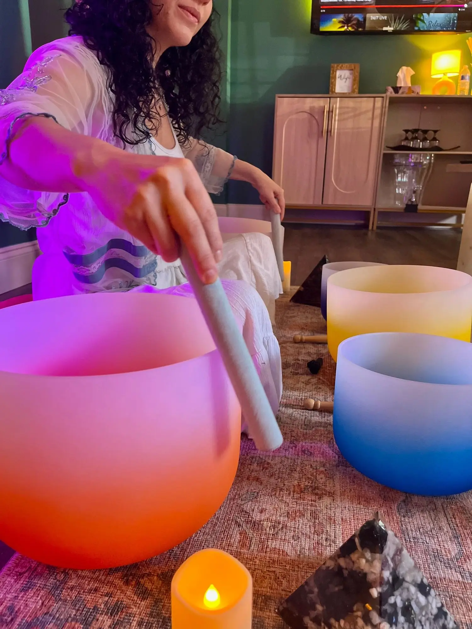 Colorful crystal singing bowls played during a sound bath